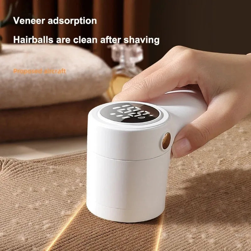 White electric lint remover with LED display, USB port, and stainless steel cutter head on a fabric background.