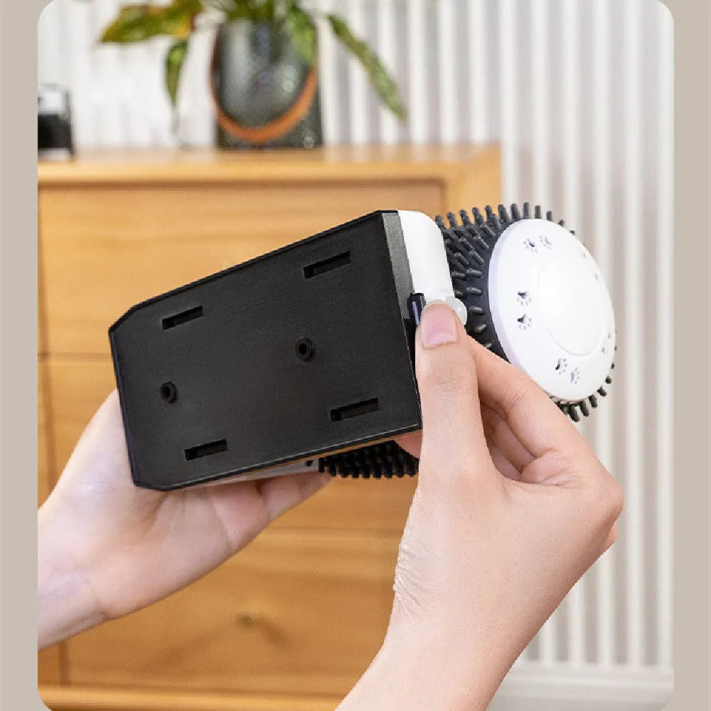 White automatic cat grooming brush mounted on a wall corner, showing USB cable and soft bristles.
