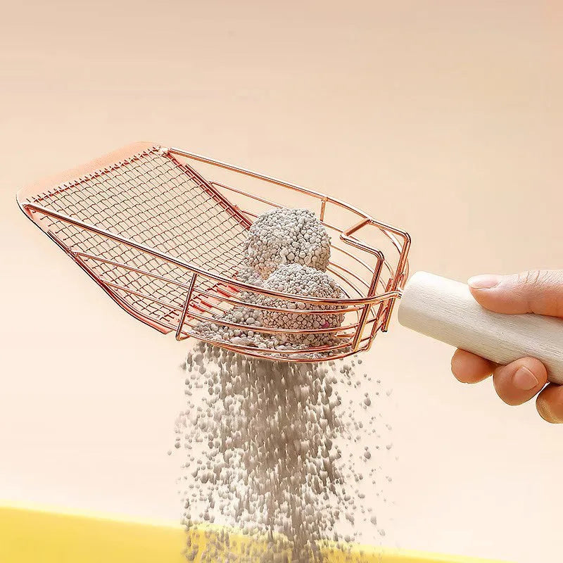 Stainless steel cat litter scoop with a long wooden handle on a litter box.