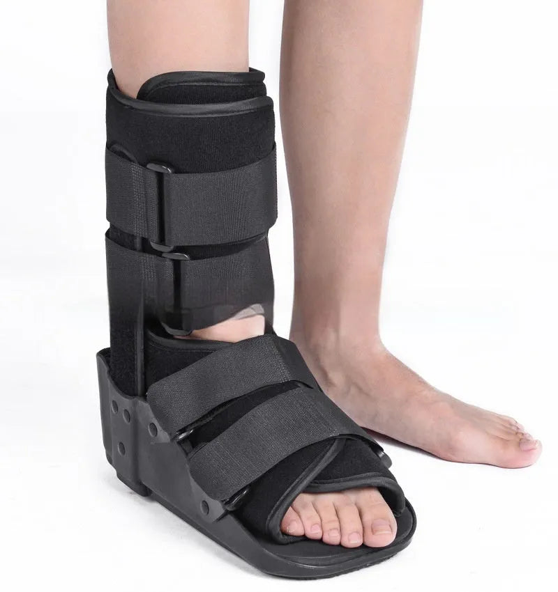 Grey Achilles tendon rehabilitation boot with aluminium frame and adjustable straps, shown with attached walking shoe.
