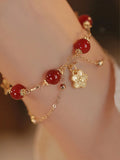 Red agate double layer bracelet with peach blossom floral details on woman's wrist