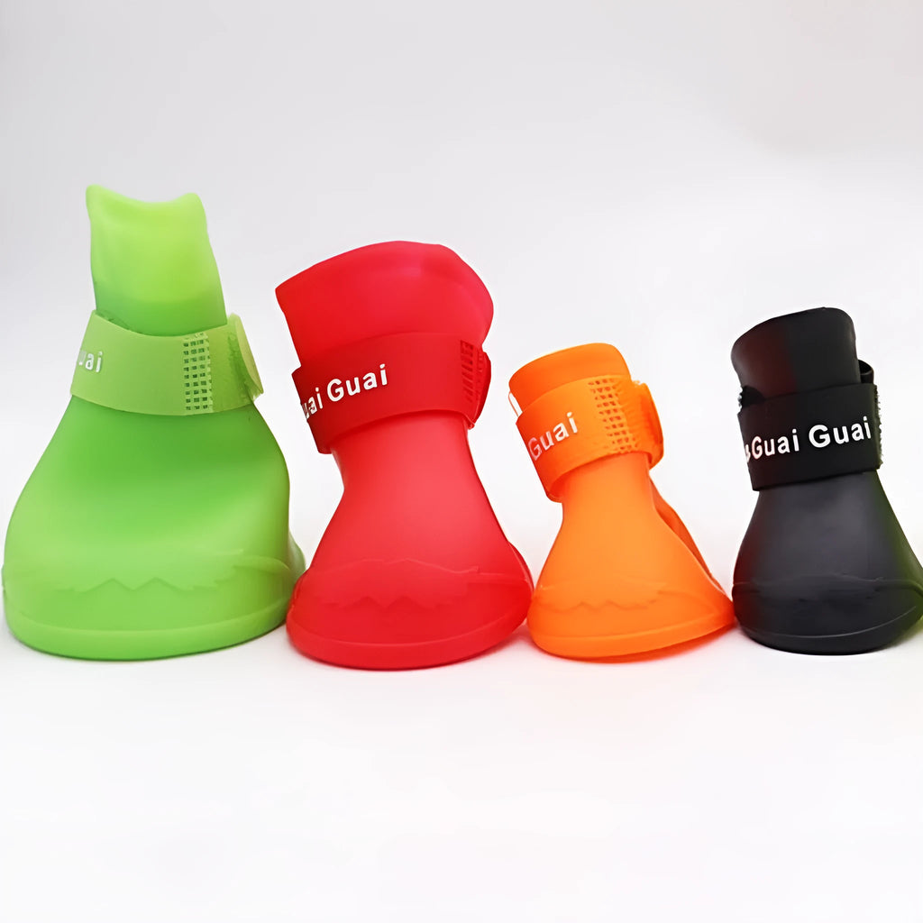 Four rubber pet rain shoes in various colours with anti-slip soles for dog paw protection