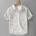 Men's grey white loose fit short sleeve cotton cardigan with a hanging dyed print, shown on a hanger.