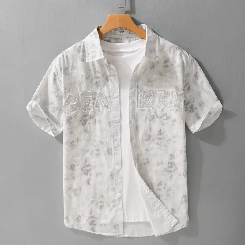 Men's grey white loose fit short sleeve cotton cardigan with a hanging dyed print, shown on a hanger.