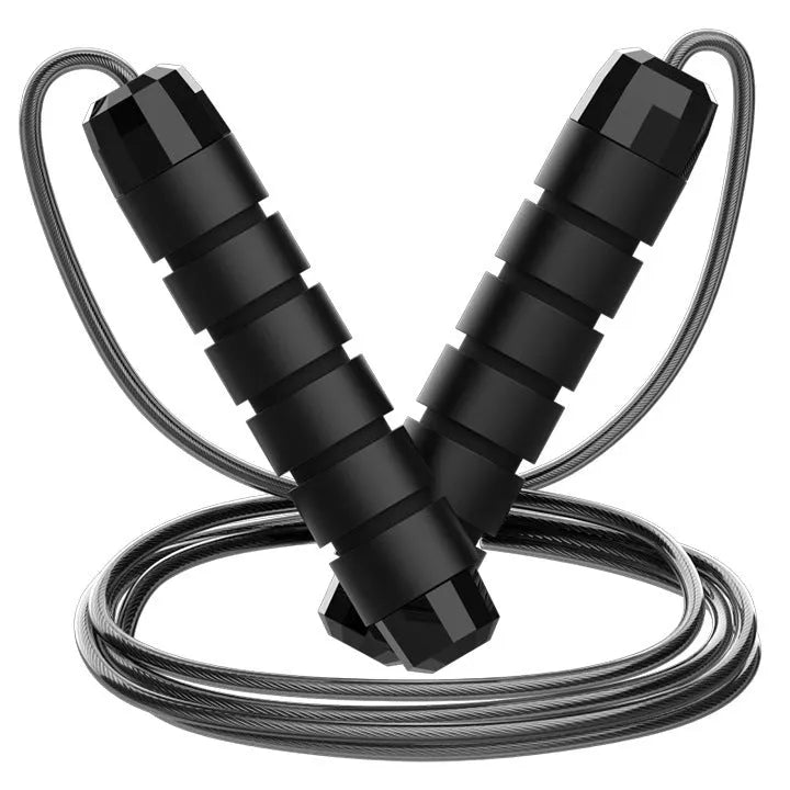 Steel wire jump rope with black PP handle on a dark background for fitness training