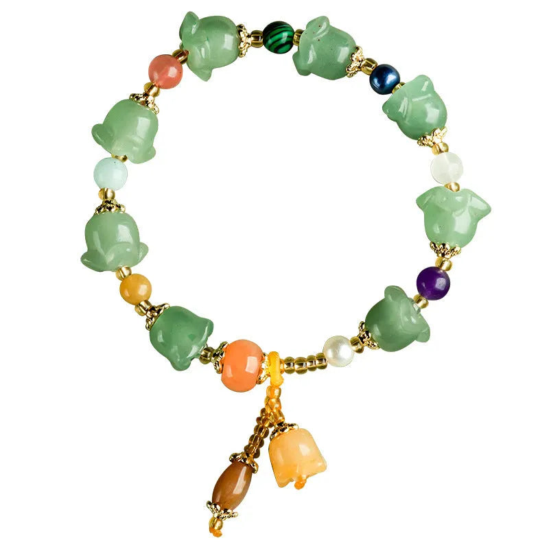 Close-up of a women's jade bracelet with hand-carved orchid-shaped beads on a wrist.